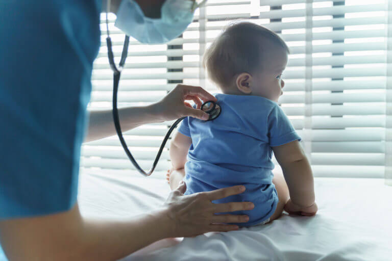 Pediatrician doctor examining her little baby