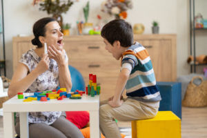 A child is playing with blocks during an autism evaluation conducted by a female pediatrician.